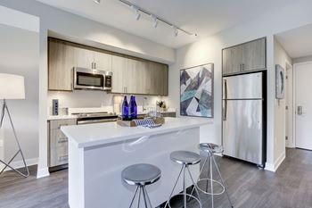 A kitchen with a white counter top and stainless steel appliances at Valo Apartments, District of Columbia